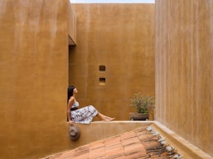 uma mulher sentada em uma borda de um edifício
