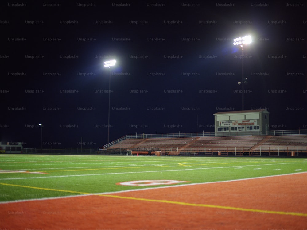 an empty football field at night with lights on