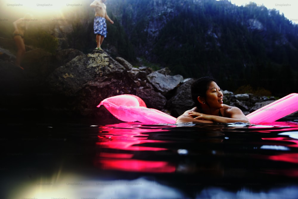 uma mulher flutuando em cima de um corpo de água