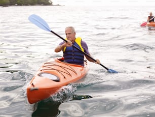 a man riding on top of a kayak in the ocean