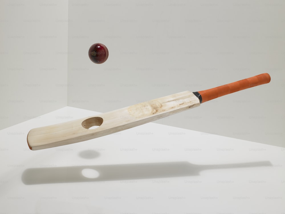 a baseball bat hitting a ball with a wooden bat
