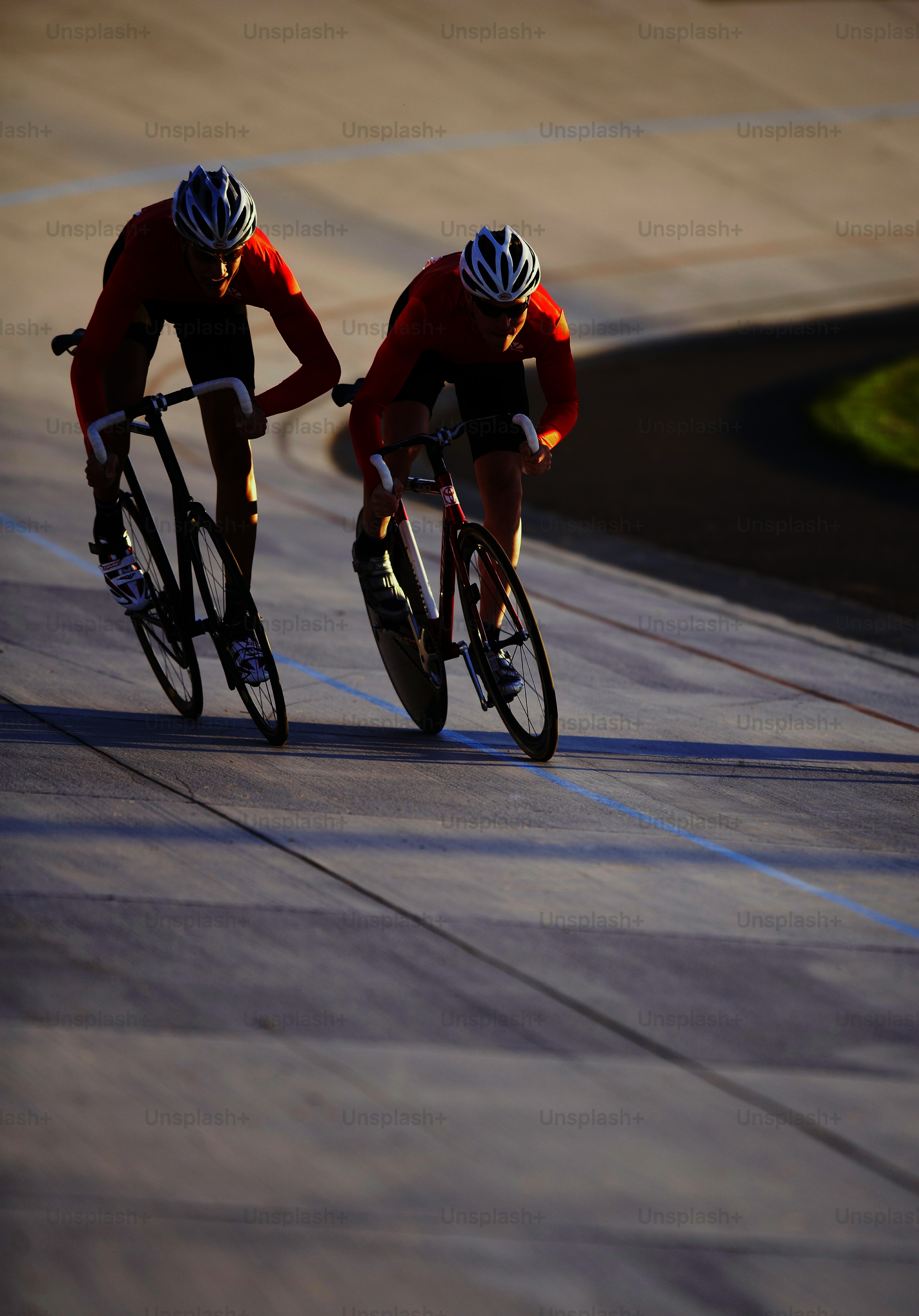 Two bicyclists racing down a paved road photo – Racing bike Image on ...