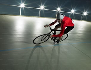 a man riding a bike down a street at night