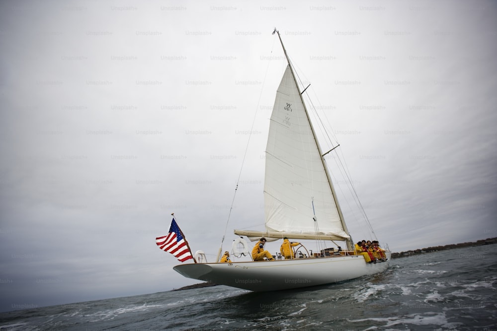 a sailboat with people on it in the water