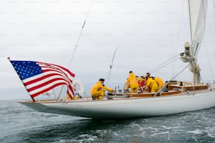 a group of people on a sailboat with an american flag