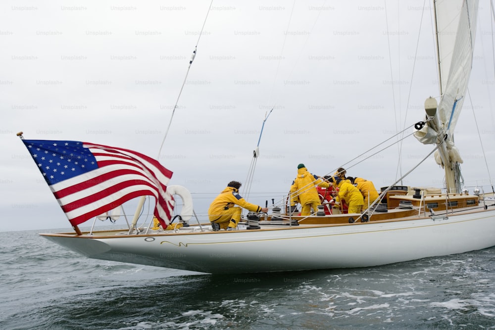 a group of people on a sailboat with an american flag