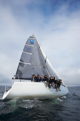 a group of people riding on the back of a sailboat