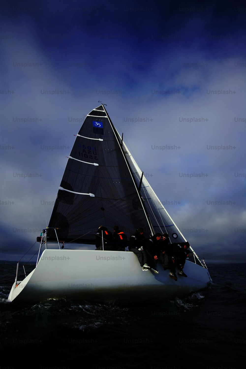 a group of people riding on the back of a sailboat