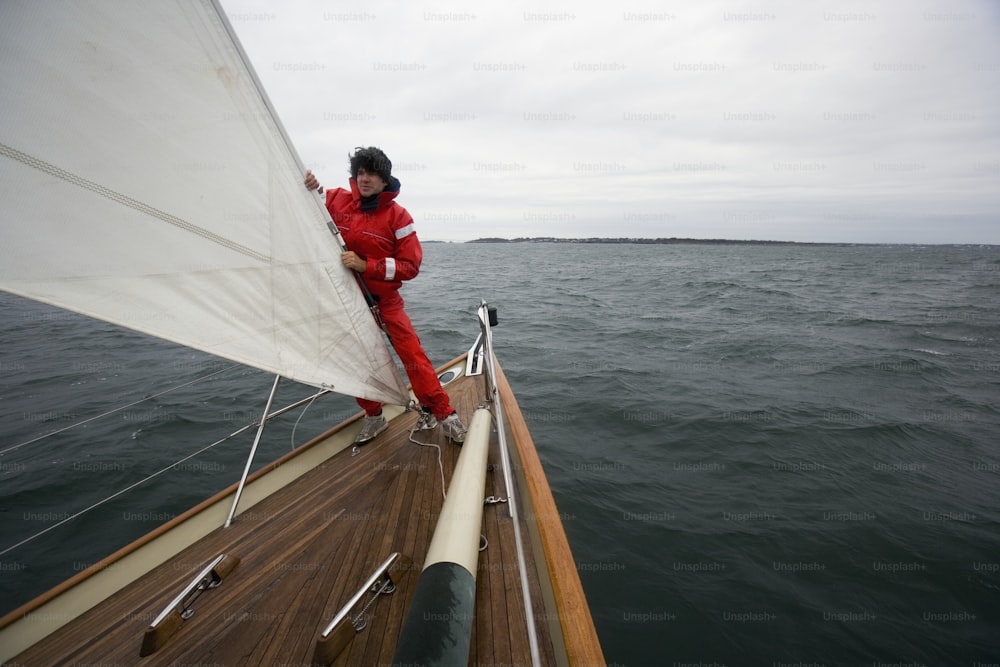 a man in a red suit is on a sailboat