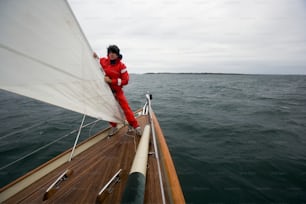 a man in a red suit is on a sailboat