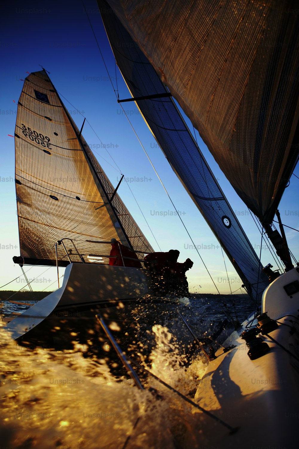 a couple of sailboats sailing on a body of water