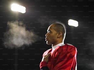 a man in a red jersey standing in front of a light