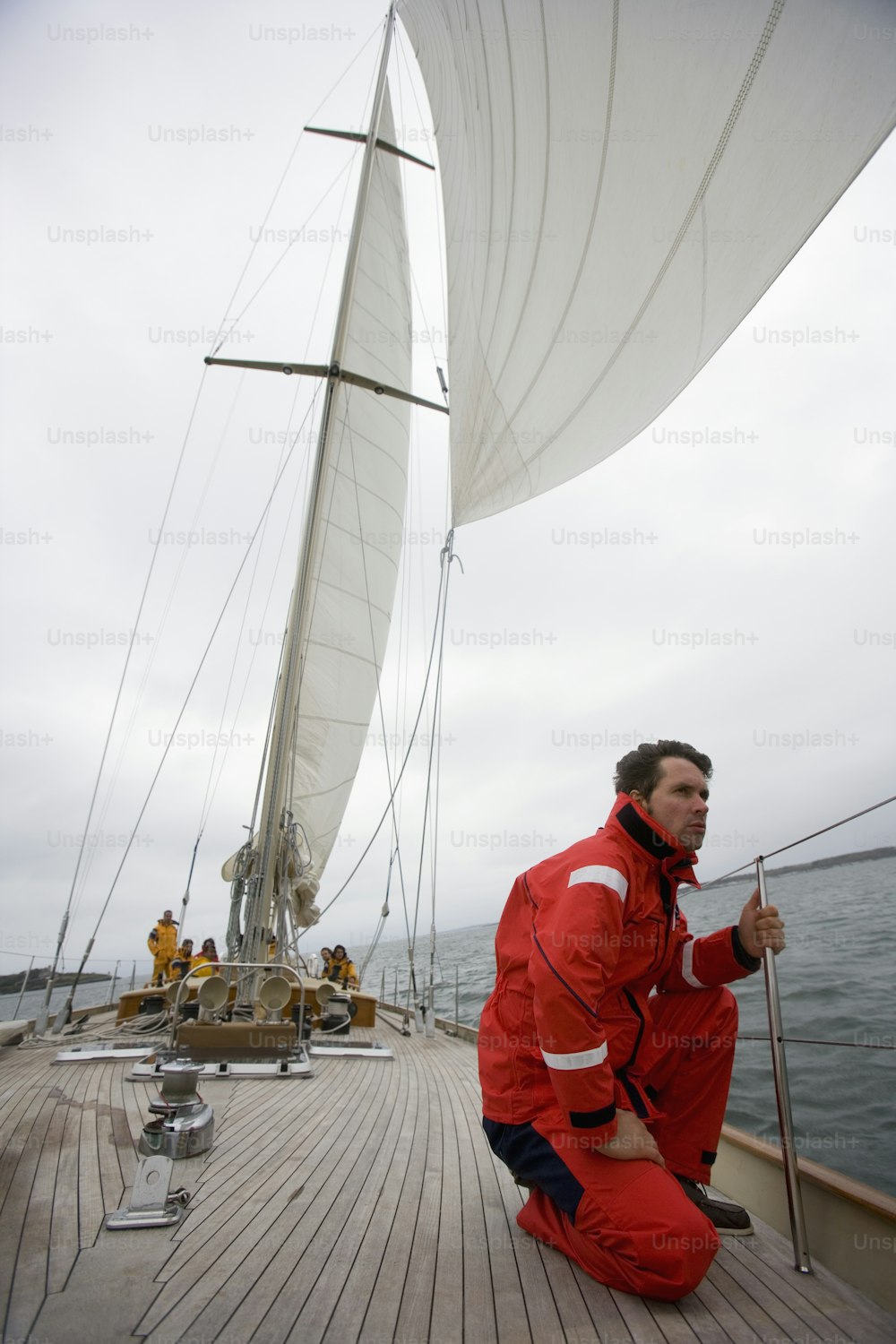 a man sitting on the deck of a sailboat