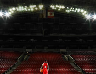 a basketball player in a red uniform standing in a stadium