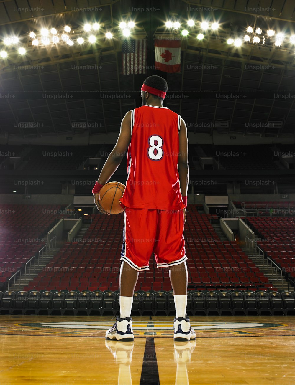 Un giocatore di basket in uniforme rossa che tiene un pallone da basket