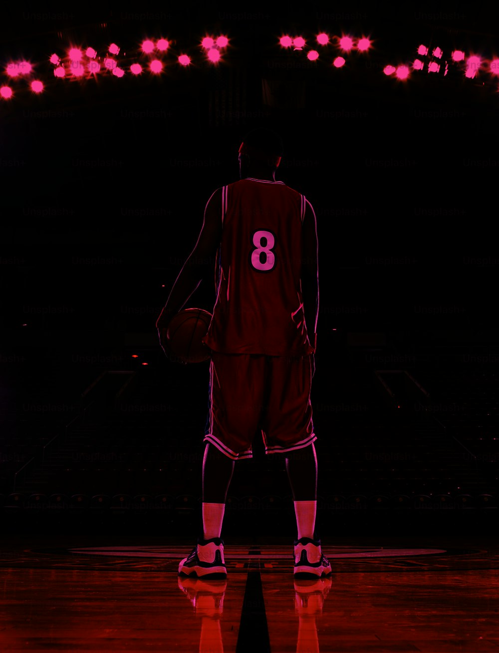a basketball player in a red uniform holding a basketball