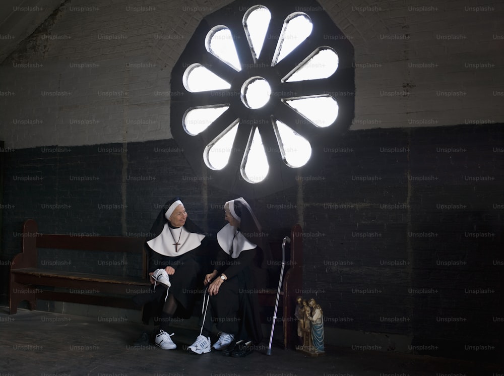 수녀와 수녀가 벤치에 앉아 있다