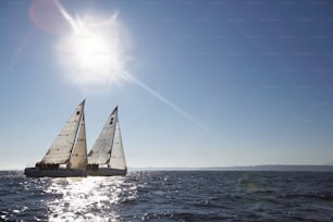 a sailboat sailing in the ocean on a sunny day