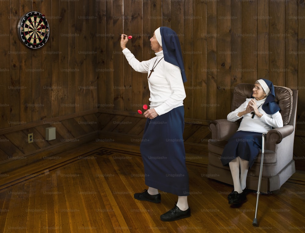 a nun and a nunette in a room with wood paneling