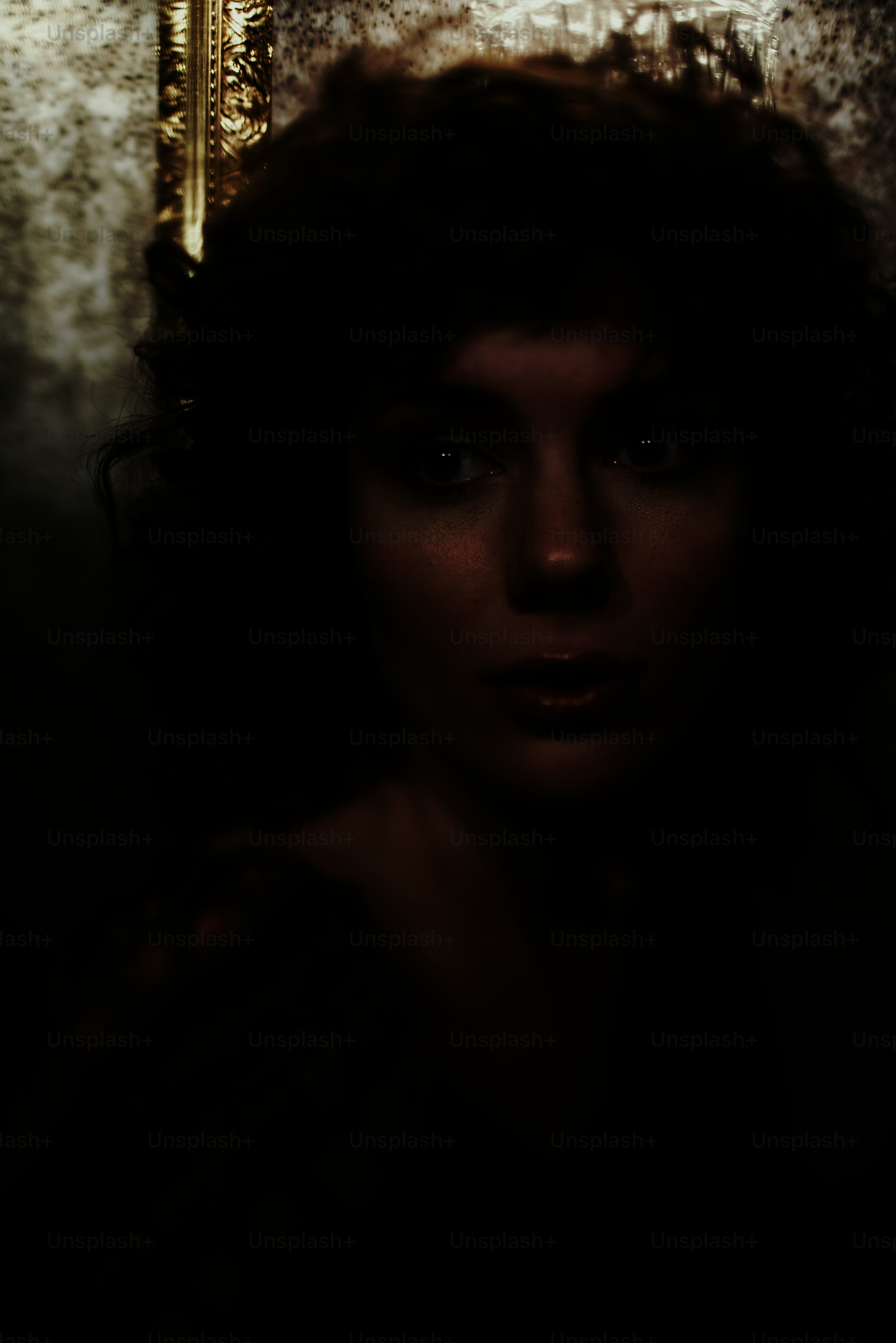 a woman with curly hair standing in front of a mirror