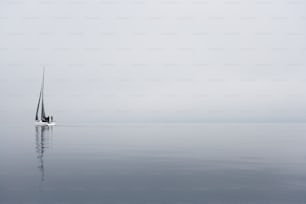 Una barca a vela in mezzo all'oceano in una giornata nebbiosa