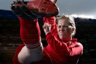 a woman in a red jacket holding a baseball glove
