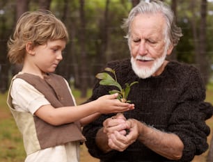 an older man and a young boy holding a plant