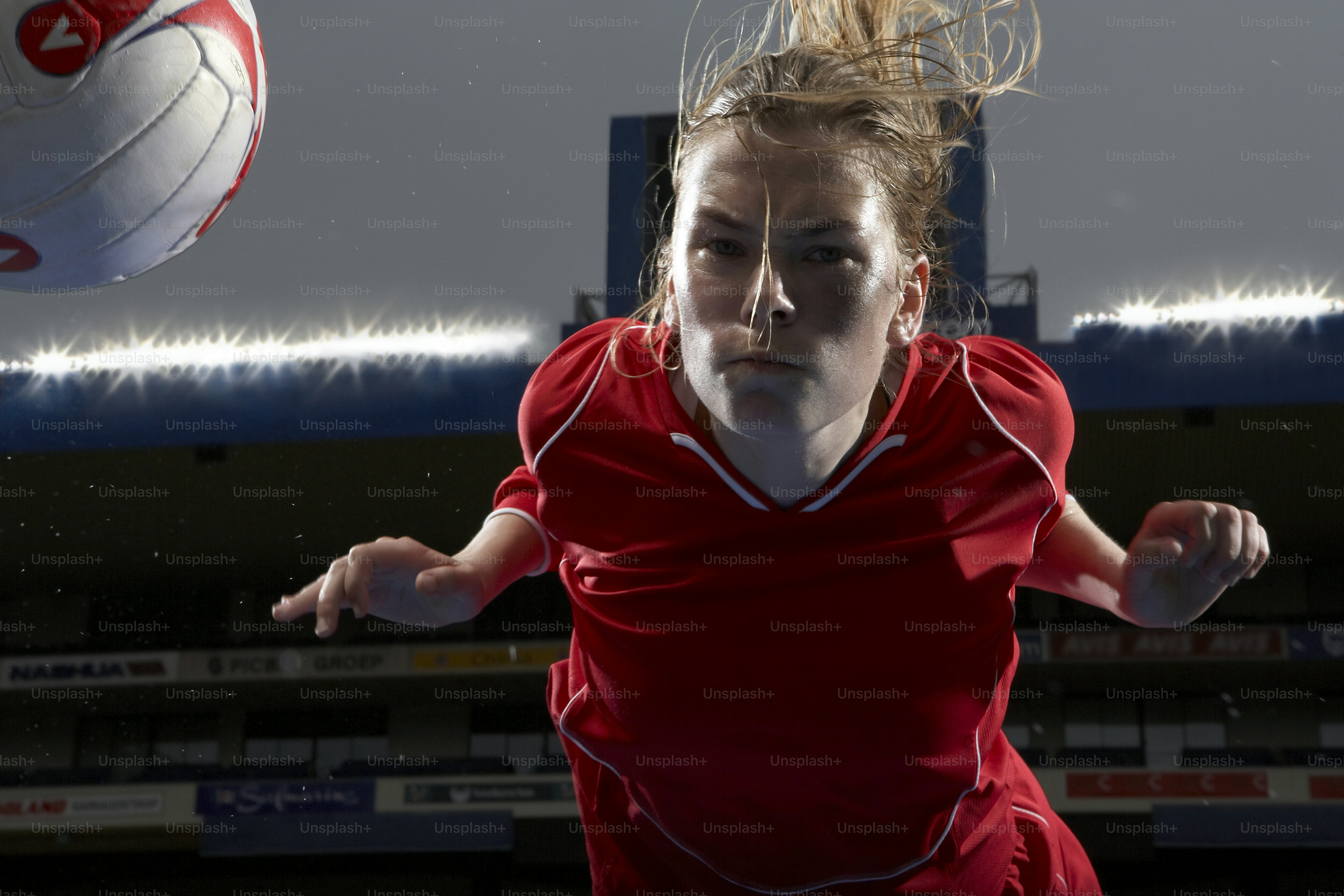 Seorang wanita berbaju merah sedang bermain bola voli
