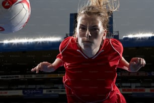 a woman in a red shirt is playing volleyball