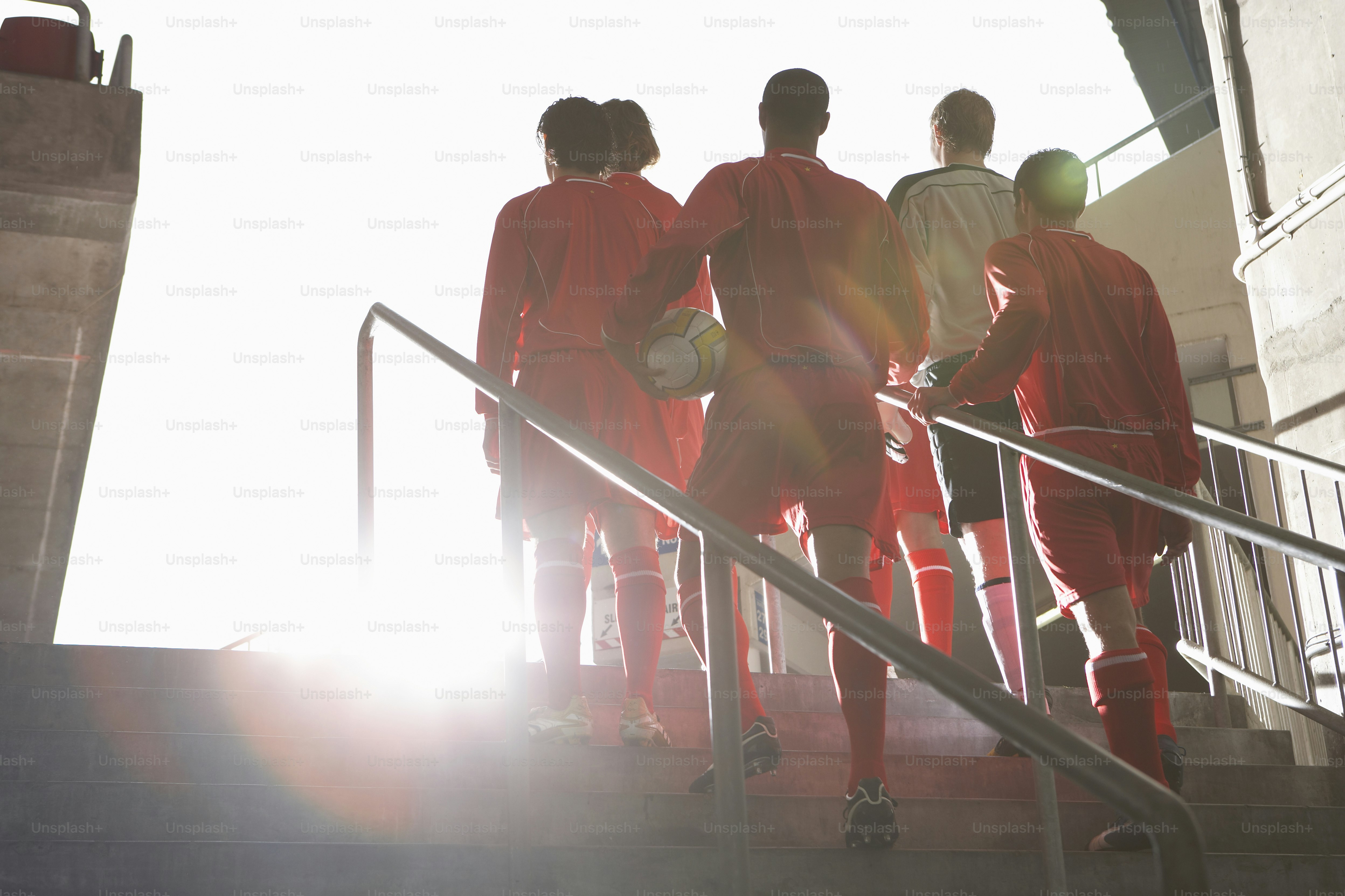 a group of soccer players walking up a flight of stairs