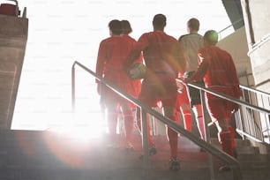 a group of soccer players walking up a flight of stairs