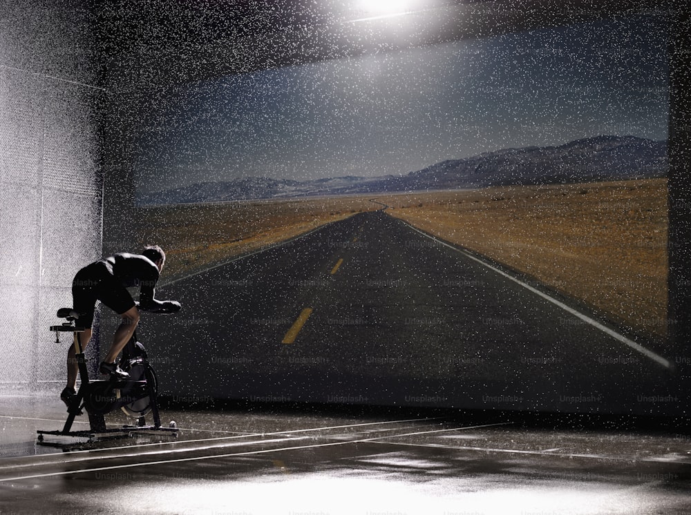Un hombre montando en bicicleta por un camino mojado