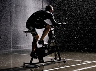 a man riding a stationary bike in the rain