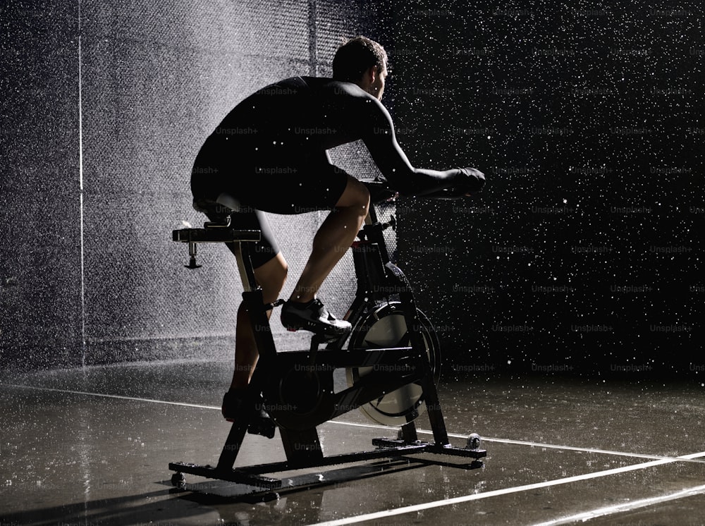 a man riding a stationary bike in the rain