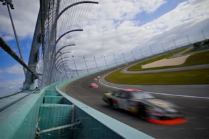 a car driving on a race track with a sky background