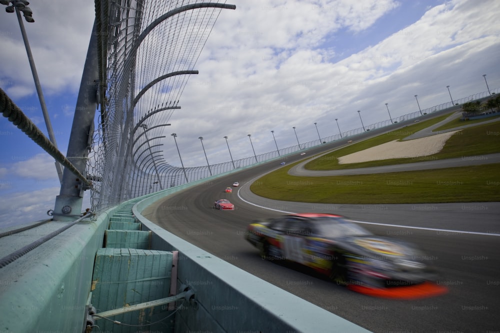 a car driving on a race track with a sky background