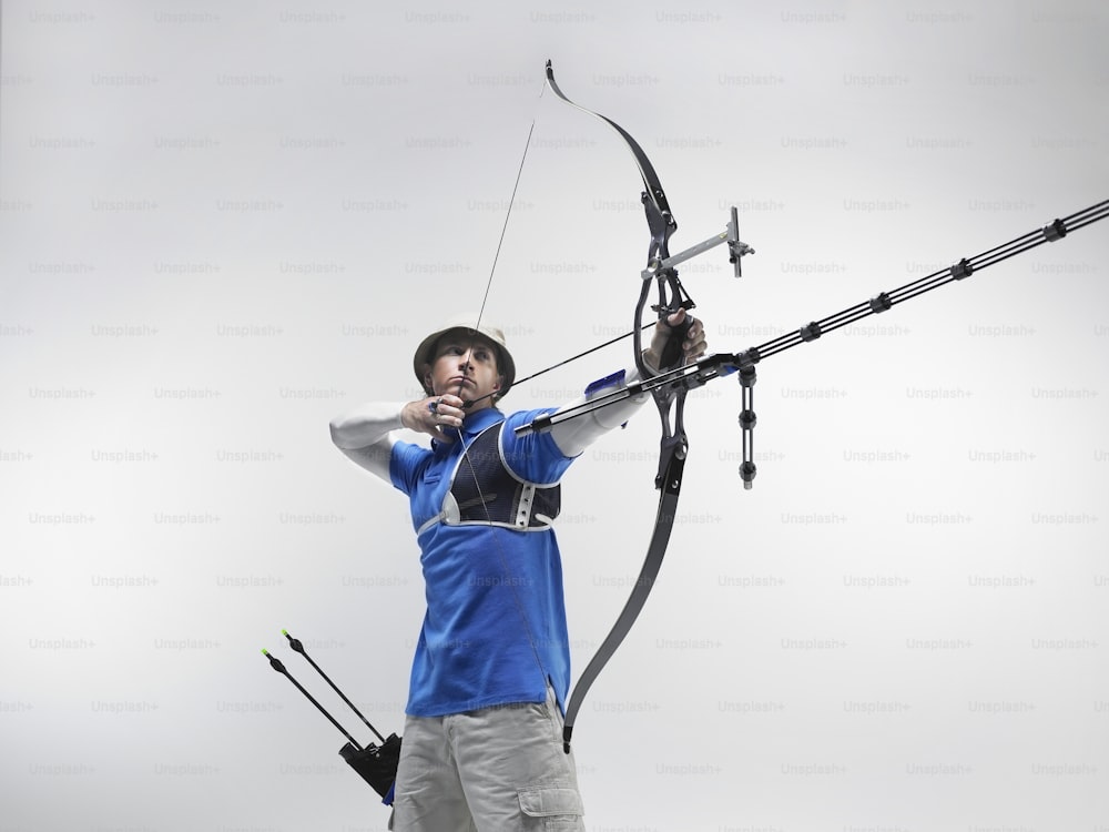 Un hombre sosteniendo un arco y una flecha en sus manos