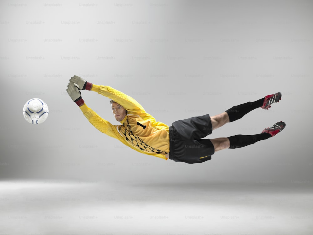 a man in a yellow shirt is kicking a soccer ball