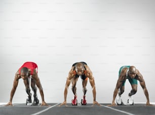 a group of three men standing on top of a race track