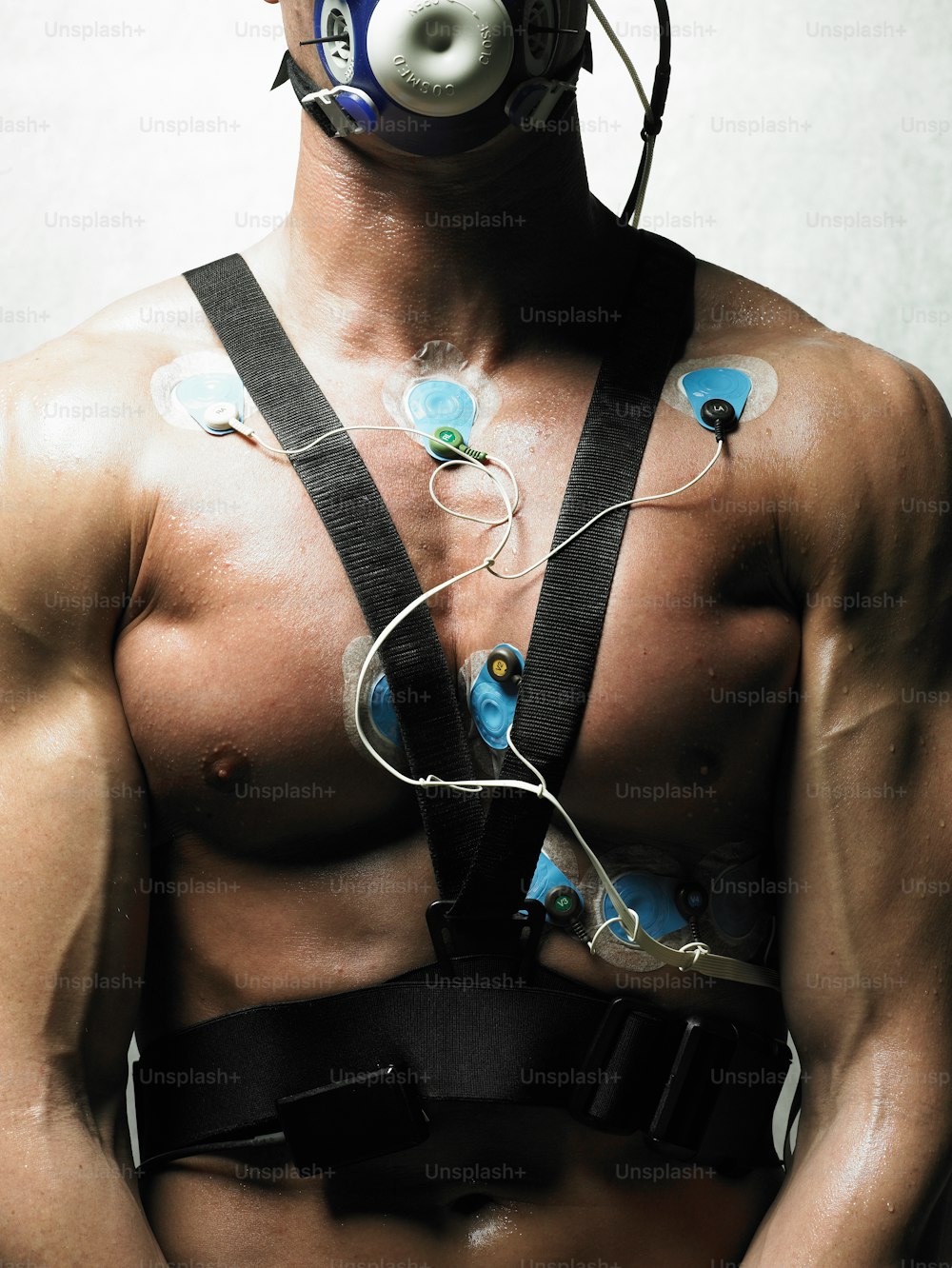 a shirtless man wearing a gas mask and harness