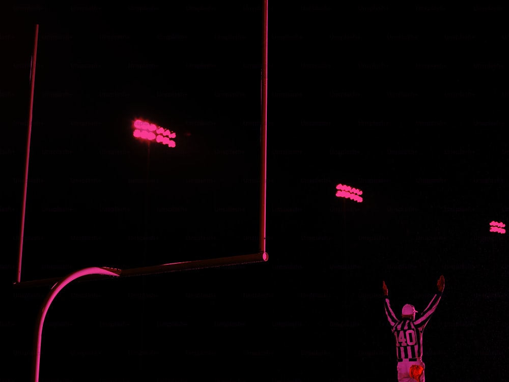 a person standing in front of a soccer goal at night