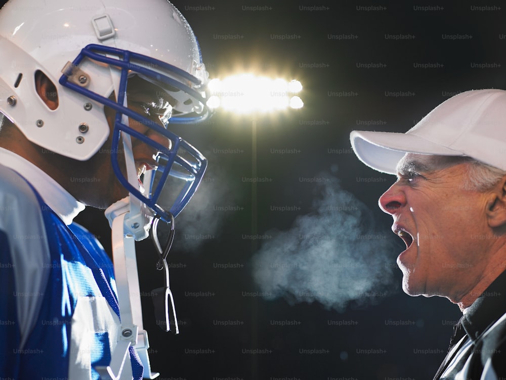 two football players with helmets on talking to each other