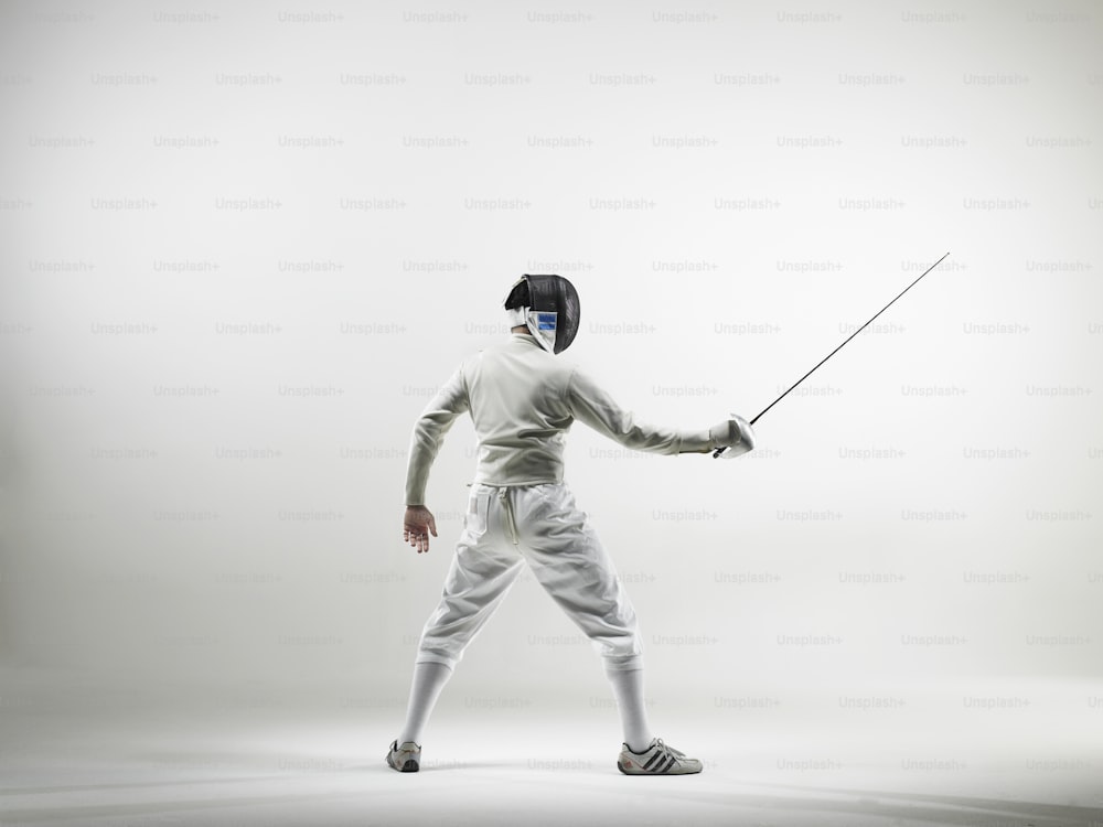 a man in a fencing outfit holding a stick