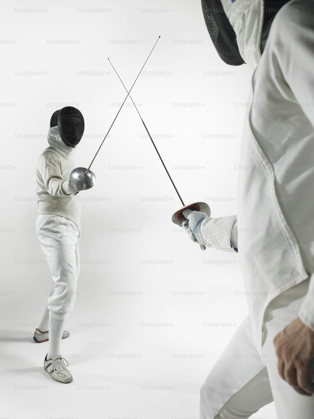 a man in fencing gear holding two fencing poles
