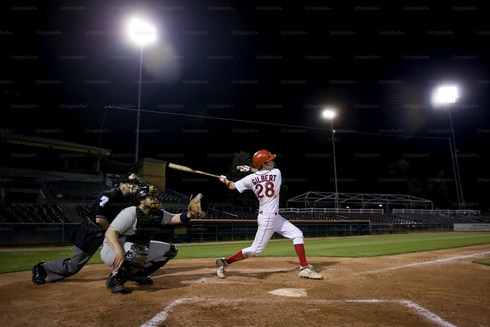 Un jugador de béisbol balanceando un bate en la parte superior de un campo
