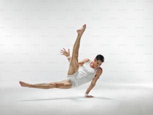 a man in white shirt and shorts doing a dance pose