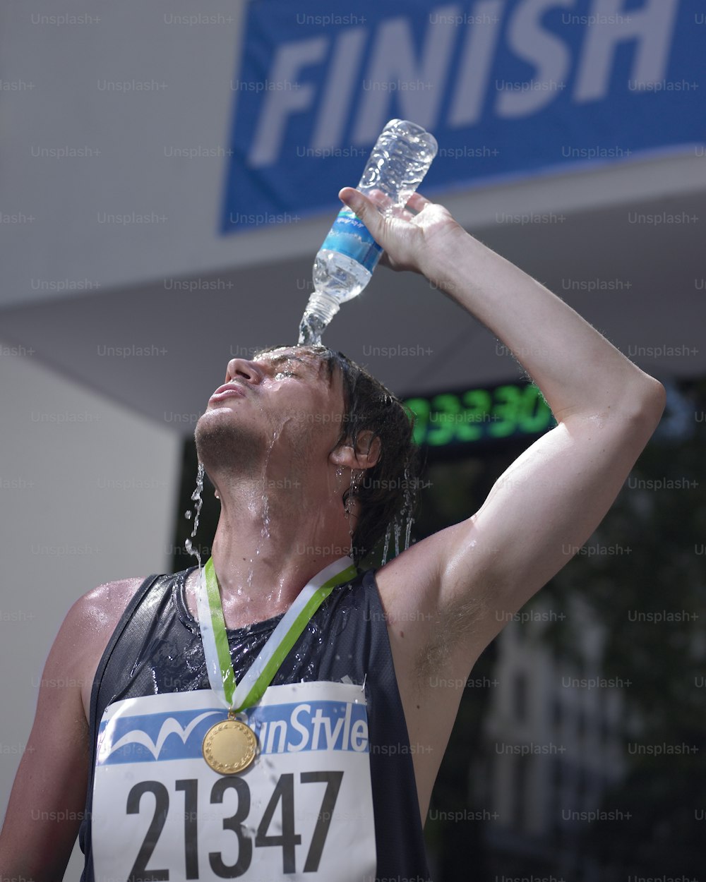 um homem bebendo água de uma garrafa de água