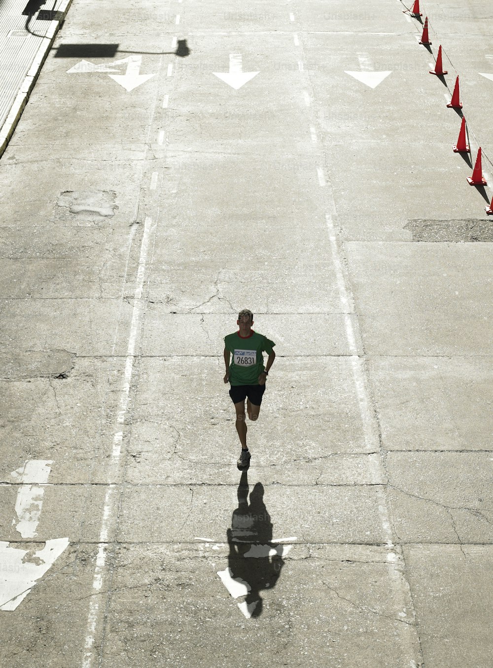 a man running down a street with a green shirt on