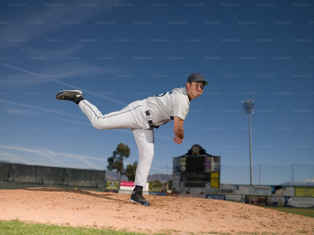 a baseball player pitching a ball on top of a field