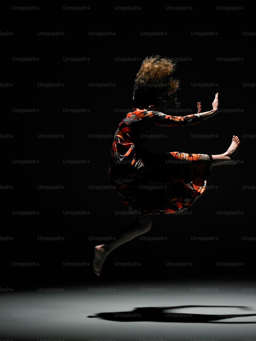 uma pessoa pulando no ar com um fundo preto